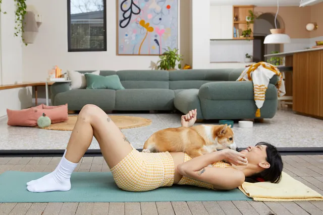 Young woman on yoga mat with dog
