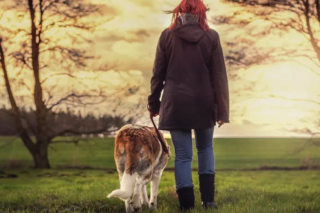 Woman and dog walking outside