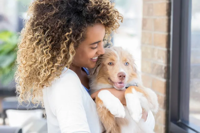 woman holding smiling puppy