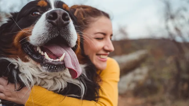 Woman cuddling dog outdoors